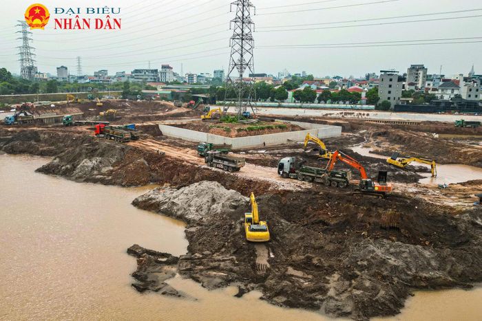 Máy xúc và xe tải hoạt động liên tục để nạo vét, vận chuyển đất ra khỏi công trường, đưa cao độ lòng hồ về đúng thiết kế