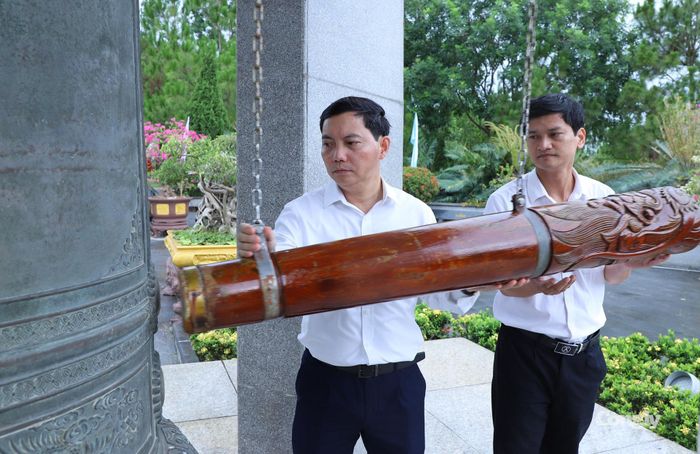 Tổng Biên tập Trần Đức Vinh cùng đồng chí Nguyễn Văn Quý, Phó Chánh án Tòa án nhân dân khu vực 5 - Quảng Trị thỉnh chuông tại Nghĩa trang Liệt sĩ Quốc gia Đường 9.