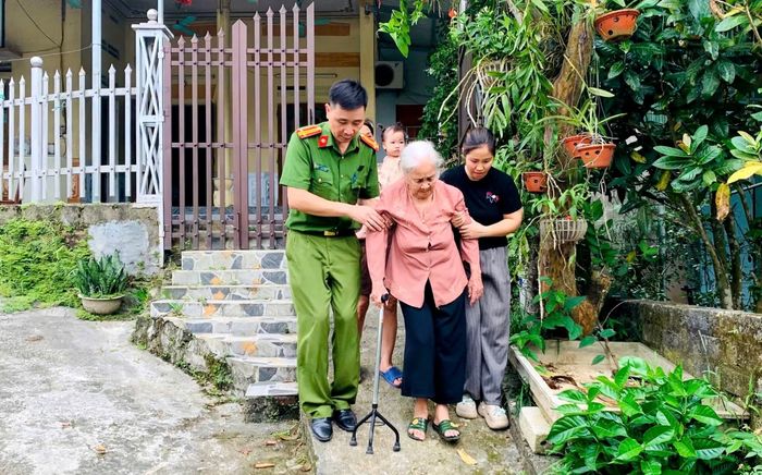 Cán bộ Công an xã Quảng Yên đến đón cụ Trần Thị Lê (90 tuổi, ở khu Đại Lục, Xã Quảng Yên) là chị ruột liệt sĩ đến điểm thu nhận mẫu sinh phẩm ADN.