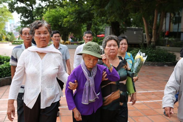  Bà Nguyễn Thị Lệ (áo tím) cùng gia đình thân nhân liệt sĩ Huỳnh Văn Quên có mặt tại Công viên Lê Thị Riêng sáng 13/7. 