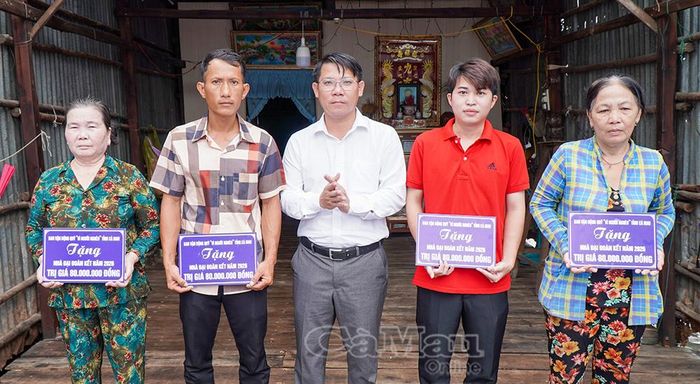 Đồng chí Trương Văn Ty, Phó Bí thư Thường trực Đảng ủy xã Đất Mũi, trao bảng tượng trưng hỗ trợ nhà cho các hộ gia đình.