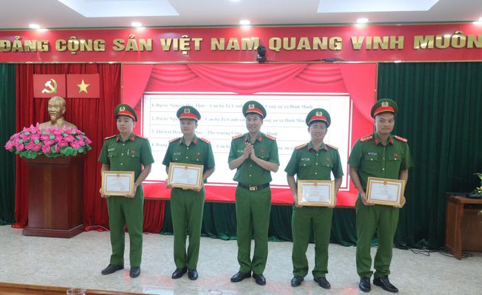 Thượng tá Bùi Văn Tứ, Trưởng Công an xã Bình Minh trao khen thưởng cho các cán bộ, chiến sĩ xuất sắc. Ảnh Đ. Đạt