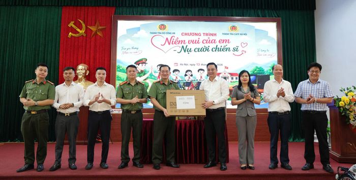 Đại tá Đoàn Đức Thắng, Chánh Thanh tra Công an thành phố Hà Nội và Bí thư Đảng ủy xã Tam Hưng Bùi Văn Sáng trao - nhận quà tại chương trình. Ảnh Bình Minh 