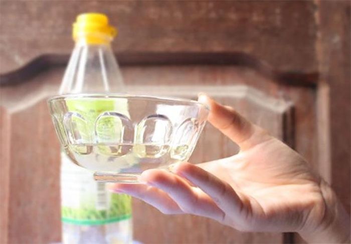 Giấm trắng có chứa axit axetic, giúp trung hòa nhiều loại mùi thực phẩm và hỗ trợ làm sạch khoang lò. Pha giấm và nước theo tỷ lệ 1:1, cho vào bát chịu nhiệt rồi quay khoảng 5 phút. Sau đó để cửa lò đóng thêm khoảng 10 phút trước khi lau sạch. Mùi giấm có thể hơi nồng lúc đầu nhưng sẽ nhanh chóng bay hết sau khi mở cửa lò.
