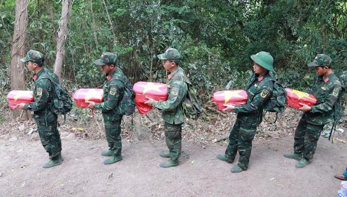 Đưa hài cốt 5 liệt sĩ xuống khỏi hang Đá Sập. Ảnh: Ngọc Vân