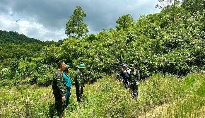 Trung tá Đào Xuân Trường cùng cán bộ, chiến sĩ và nhân dân địa phương đang kiểm tra thực địa khu đất có thông tin về phần mộ bộ đội hy sinh trên địa bàn.