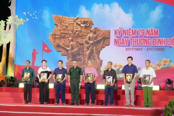 Thượng tướng Lê Quang Minh, Phó Chủ nhiệm Tổng cục Chính trị Quân đội nhân dân Việt Nam trao ảnh phục dựng liệt sĩ cho thân nhân các liệt sĩ.