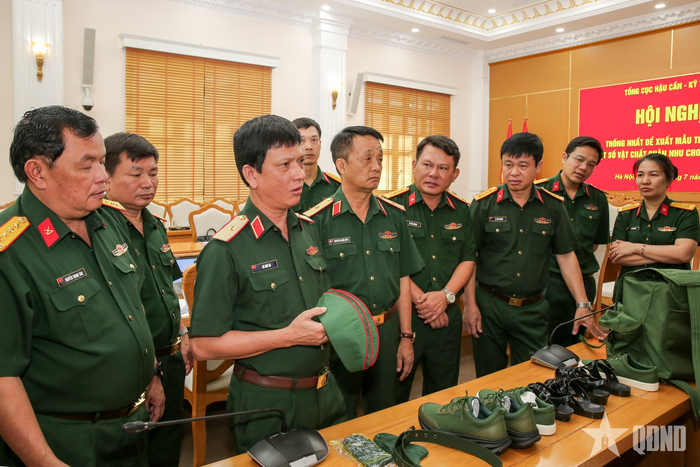  Thiếu tướng Hà Như Lợi và các đại biểu kiểm tra chất lượng một số mẫu trang phục và vật chất quân nhu được trưng bày tại hội nghị. 