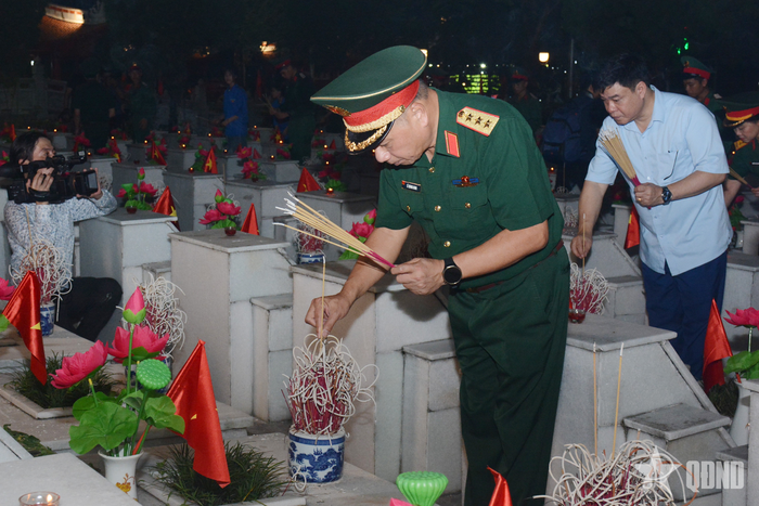 Thượng tướng Lê Quang Minh và các đại biểu thắp nến, thắp hương tại các phần mộ trong Nghĩa trang Liệt sĩ quốc gia Vị Xuyên.