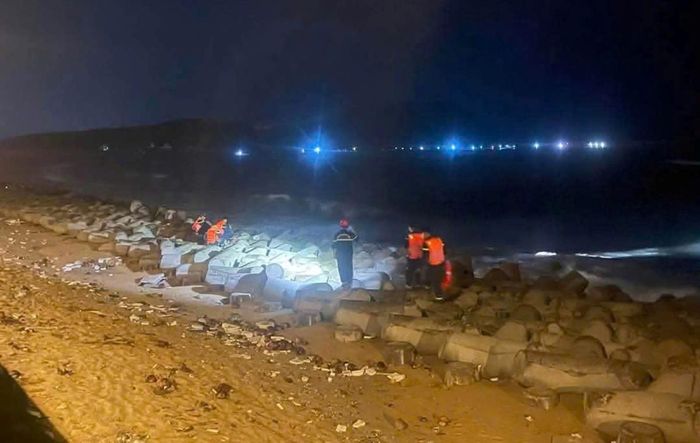 Lực lượng chức năng tìm kiếm nạn nhân bị sóng biển cuốn mất tích.