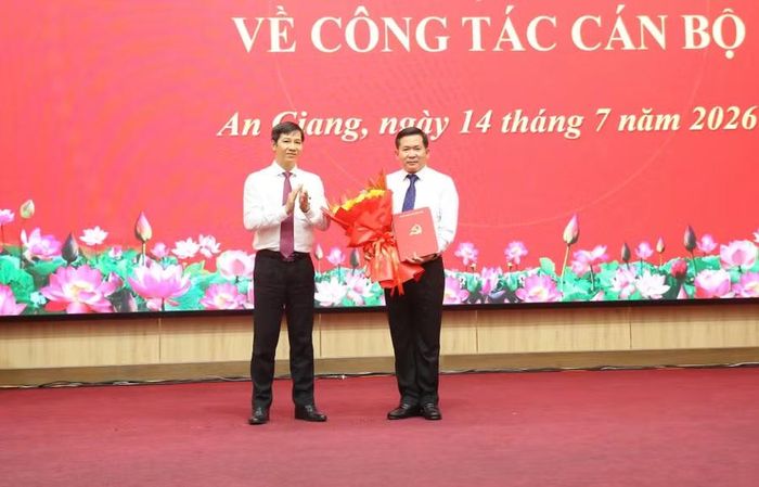 Ông Nguyễn Thành Tâm, Phó Trưởng Ban Tổ chức Trung ương, trao quyết định và tặng hoa cho ông Đinh Văn Nơi.