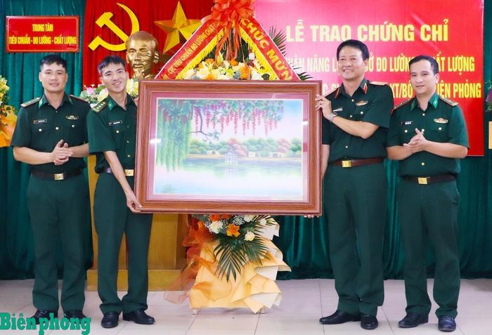 Thiếu tướng Nguyễn Hoàng Ngọc Dũng tặng hoa và quà lưu niệm chúc mừng Trung tâm Tiêu chuẩn - Đo lường - Chất lượng, Cục Hậu cần - Kỹ thuật Bộ đội Biên phòng. Ảnh: Dân Chủ