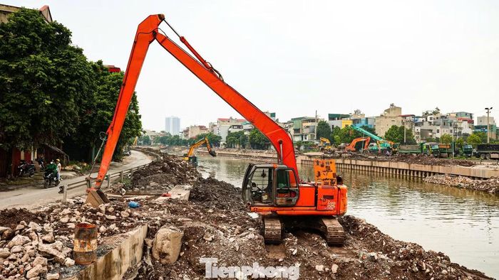 Nhiều máy móc và công nhân được huy động thi công đồng loạt các hạng mục kè bê tông, nạo vét lòng sông gần trạm bơm Yên Sở.