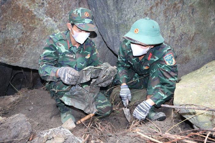 Cán bộ, chiến sĩ thận trọng bóc tách từng lớp đất đá, tìm kiếm hài cốt và di vật liệt sĩ trong Hang Đá Sập.