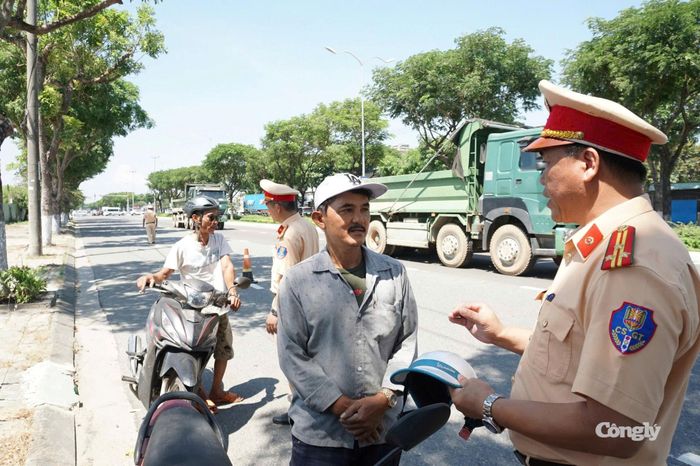 CSGT tuyên truyền trực tiếp, nhắc nhở người dân chấp hành quy định đội mũ bảo hiểm.