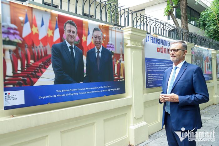 Đại sứ Olivier Brochet bên triển lãm ảnh về quan hệ hai nước trưng bày xung quanh Đại sứ quán