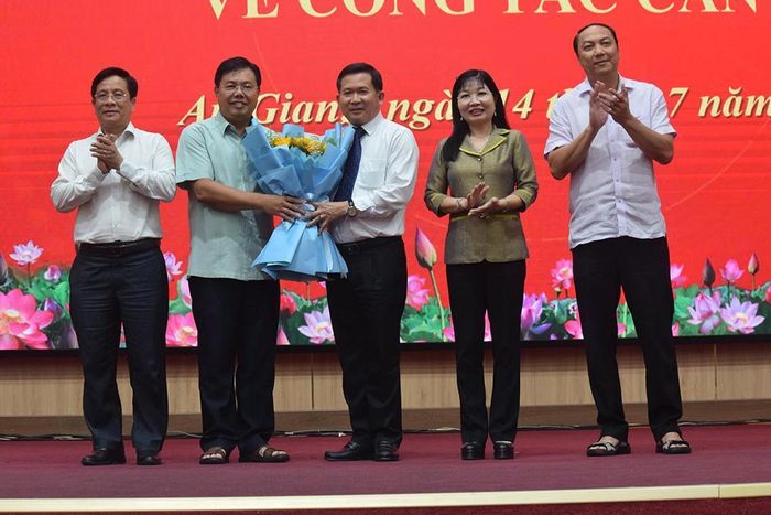 Ông Đinh Văn Nơi (đứng giữa) nhận hoa chúc mừng. Ảnh: CTV