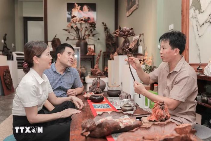 Chính quyền xã Thư Lâm trực tiếp đến từng cơ sở sản xuất để phổ biến về mô hình xã xã hội chủ nghĩa, lắng nghe và đồng hành cùng người dân trong quá trình xây dựng nếp sống văn minh, bền vững. (Ảnh: Phan Phương/TTXVN)