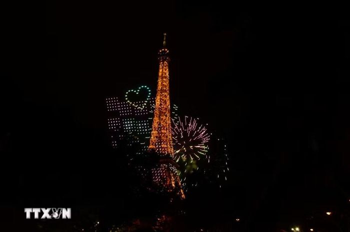 Các thiết bị bay không người lái (drone) tạo hình trên bầu trời, cạnh Tháp Eiffel trong chương trình trình diễn ánh sáng chào mừng Quốc khánh Pháp tại Paris tối 13/7/2026. (Ảnh: Hữu Chiến/TTXVN)