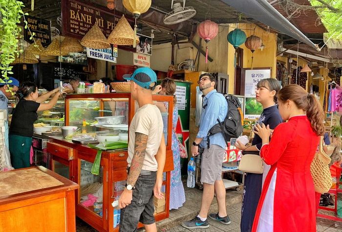Du khách xếp hàng mua bánh mỳ ở Hội An. (Ảnh: Xuân Mai/Vietnam+)