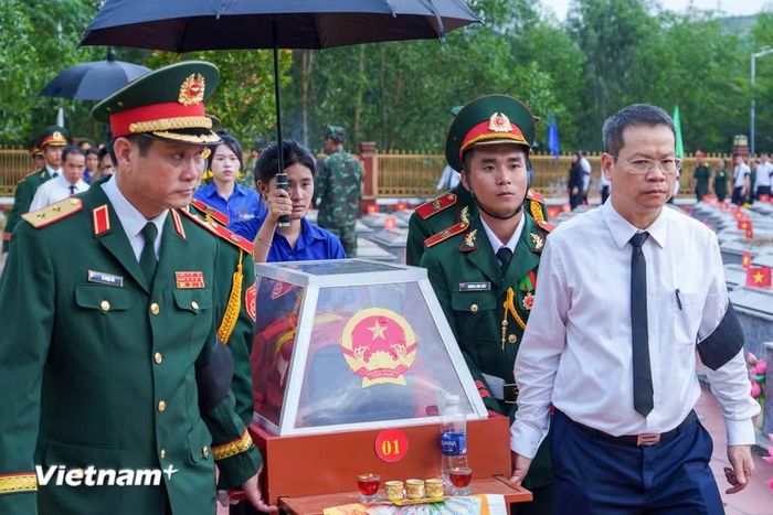 Trung tướng Lê Ngọc Hải (hàng đầu, bên trái), Ủy viên Trung ương Đảng, Tư lệnh Quân khu 5 cùng Phó Bí thư Thành ủy, Chủ tịch Ủy ban nhân dân thành phố Nguyễn Mạnh Hùng (áo trắng, bên phải) cẩn thận đưa hài cốt các liệt sĩ về nơi yên nghỉ. (Ảnh: Thanh Phong/Vietnam+)