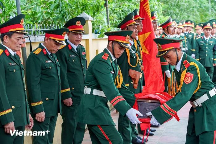 Đội tiêu binh cẩn trọng đưa hài cốt các liệt sĩ về nơi yên nghỉ. (Ảnh: Thanh Phong/Vietnam+)