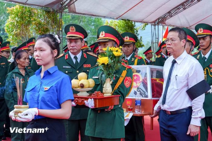 Trung tướng Lê Ngọc Hải, Ủy viên Trung ương Đảng, Tư lệnh Quân khu 5 cùng Phó Bí thư Thành ủy, Chủ tịch Ủy ban nhân dân thành phố Nguyễn Mạnh Hùng cẩn thận đưa hài cốt các liệt sĩ về nơi yên nghỉ. (Ảnh: Thanh Phong/Vietnam+)