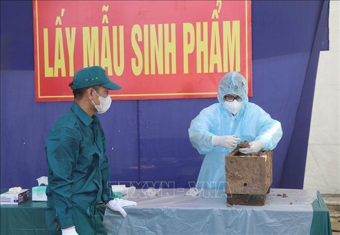 Lực lượng chức năng lấy mẫu hài cốt liệt sĩ tại Nghĩa trang liệt sĩ xã Ý Yên, tỉnh Ninh Bình.