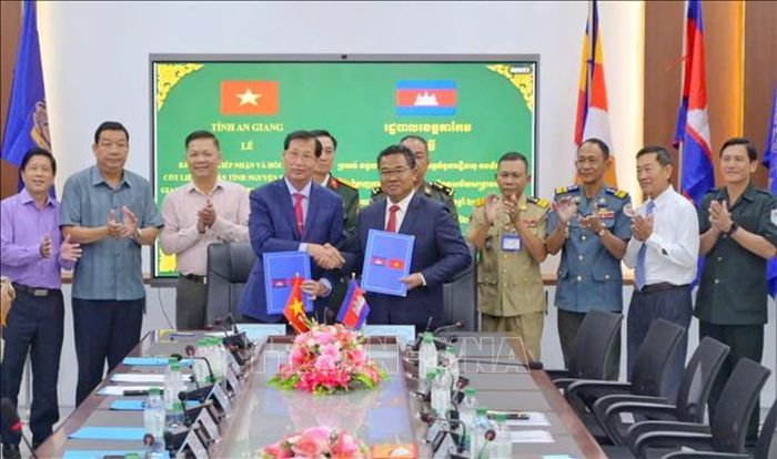 Ban chuyên trách 2 tỉnh ký kết biên bản bàn giao, tiếp nhận hài cốt liệt sĩ. Ảnh: TTXVN phát
