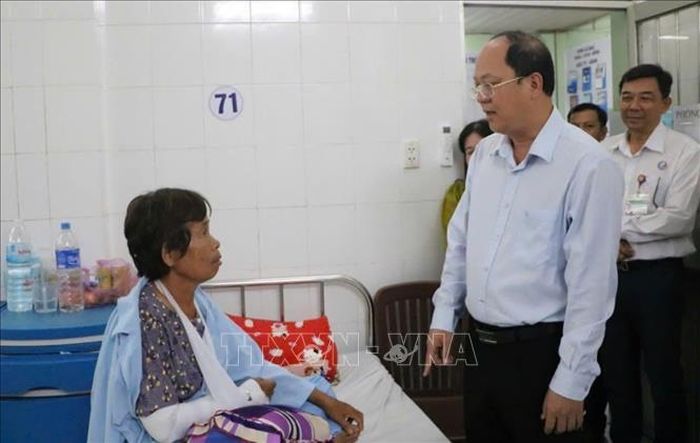 Bí thư Tỉnh ủy Nguyễn Hồ Hải thăm hỏi, động viên bà Nguyễn Thị Bình đang điều trị tại Bệnh viện Đa khoa Cà Mau sau khi bị thương trong trận dông lốc ngày 13/7. Ảnh: TTXVN phát