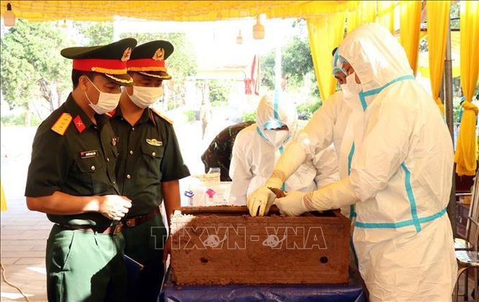 Thực hiện lấy mẫu hài cốt Liệt sĩ tại Nghĩa trang Liệt sĩ xã Tân Cương. Ảnh: Trần Trang/TTXVN