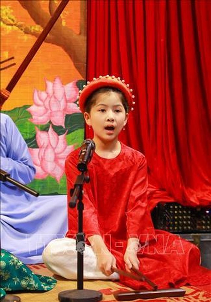 Em Nguyễn Bảo Ngọc (8 tuổi, Hà Nội) - thành viên nhí của Câu lạc bộ Ca trù Bích Câu tham gia biểu diễn cùng các nghệ nhân. Ảnh: Khánh Hòa/TTXVN