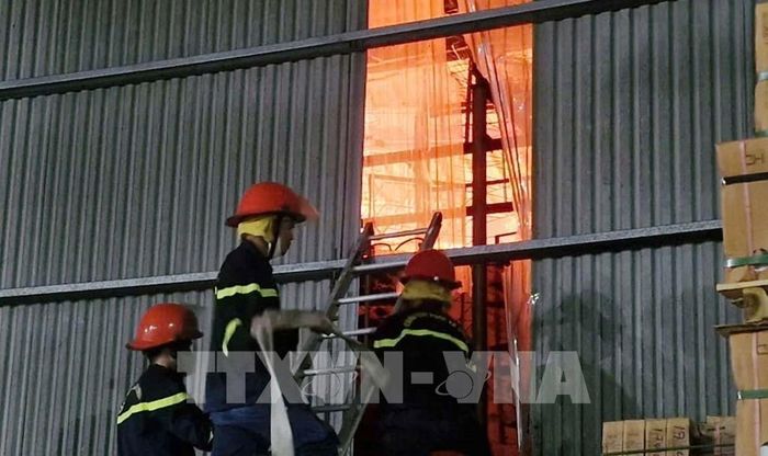 Cháy lớn tại khu vực tầng 2 nhà kho chứa giầy của Công ty Trách nhiệm hữu hạn một thành viên tự động hóa máy giầy Toàn Thịnh Việt Nam nên lực lượng chữa cháy khó khan tiếp cận. Ảnh: Việt Hoàng - TTXVN