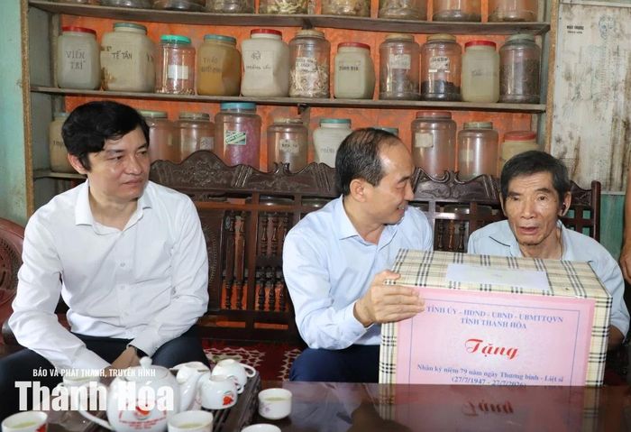 Phó Chủ tịch Thường trực HĐND tỉnh Lê Tiến Lam tặng quà cho ông Nguyễn Tiến Dũng.