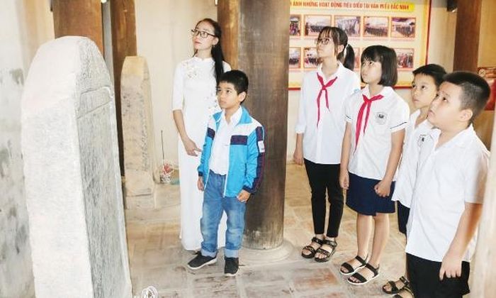 Học sinh tham quan, tìm hiểu di tích thông qua các văn bia cổ.