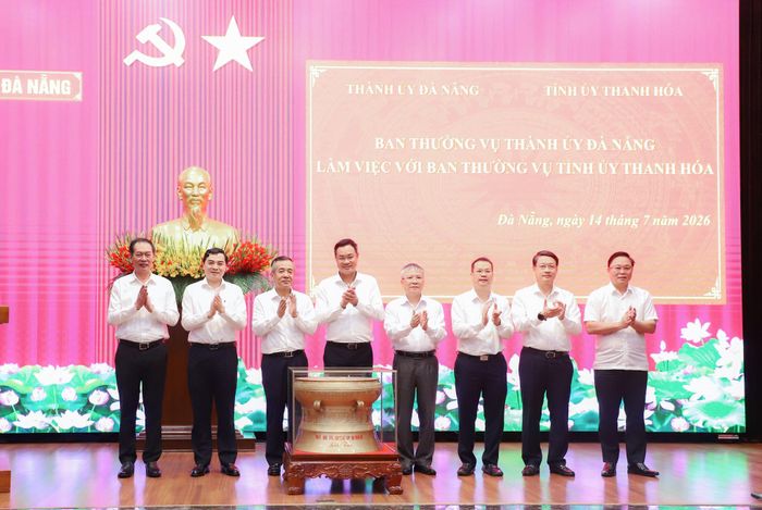 Lãnh đạo tỉnh Thanh Hóa (bên trái) trao quà lưu niệm cho lãnh đạo thành phố Đà Nẵng. Ảnh: NGỌC PHÚ