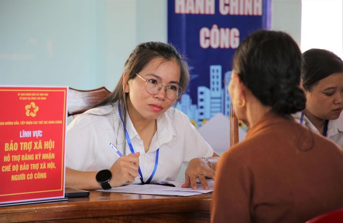 Cán bộ xã Tam Anh hỗ trợ người dân thực hiện thủ tục hành chính. Ảnh: ALĂNG NGƯỚC
