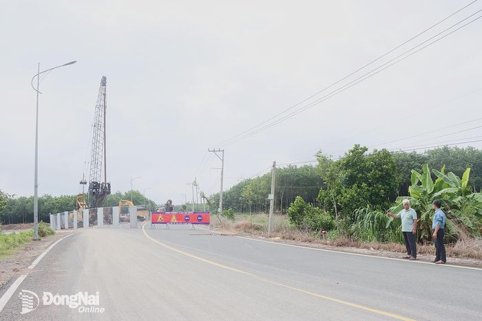 Ông Dương Văn Thảo (bên trái), ở ấp 2, xã Nha Bích chỉ phần đất gia đình ông đã bàn giao mặt bằng để thi công cao tốc Gia Nghĩa - Chơn Thành.
