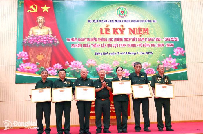 Tiến sĩ Đặng Mạnh Trung, nguyên Vụ trưởng cơ quan thường trực Ban Tuyên giáo Trung ương (nay là Ban Tuyên giáo và Dân vận Trung ương) trao bằng khen của Trung ương Hội Cựu thanh niên xung phong Việt Nam cho các cá nhân xuất sắc trong học tập và làm theo tư tưởng, đạo đức, phong cách Hồ Chí Minh. Ảnh: Nguyệt Hà