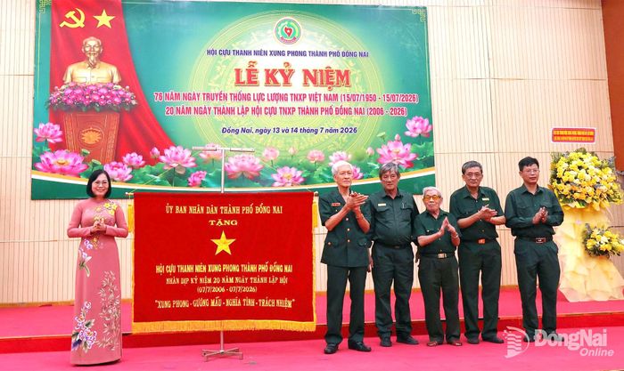 Thành ủy viên, Phó Chủ tịch UBND thành phố Đồng Nai Nguyễn Thị Hoàng tặng bức trướng của UBND thành phố cho Hội Cựu thanh niên xung phong thành phố. Ảnh: Nguyệt Hà