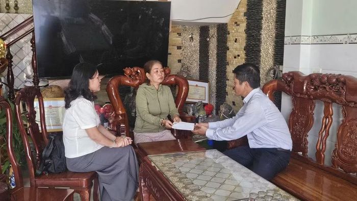 Phó Chủ tịch Ủy ban MTTQ Việt Nam tỉnh Đinh Ngọc Hải (bên phải) tặng quà cho chủ tàu cá bị cháy tại phường Hoài Nhơn Bắc. Ảnh: Ngọc Anh