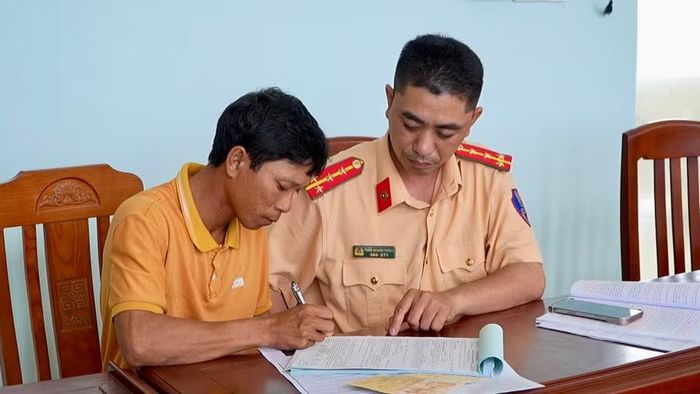 Tài xế ký biên bản vi phạm hành chính và cam kết sẽ chấp hành các quy định về trật tự, an toàn giao thông. Ảnh: Nhật Trường