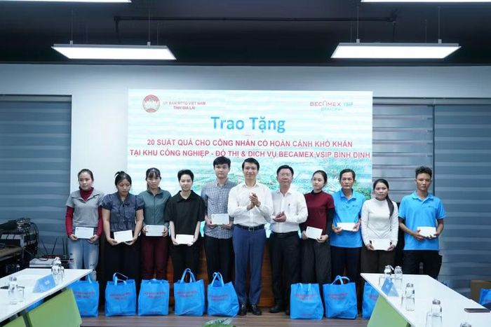 Đồng chí Nguyễn Ngọc Lương (thứ 6 từ trái sang) tặng quà cho các công nhân có hoàn cảnh khó khăn. Ảnh: N.H
