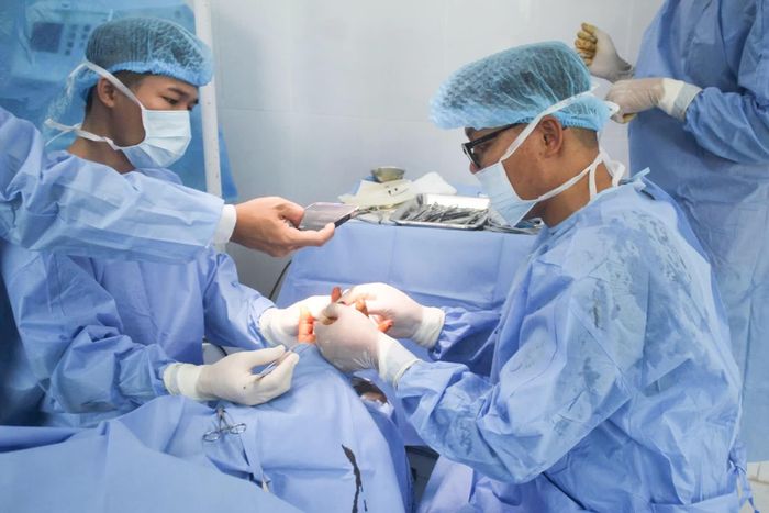 Các y, bác sĩ tiến hành phẫu thuật vết thương cho bệnh nhân.