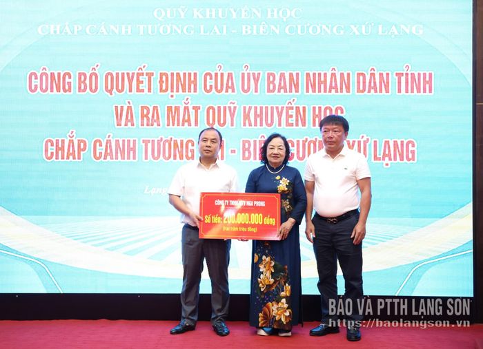 Đại diện Công ty TNHH MTV Nga Phong trao biển tượng trưng kinh phí ủng hộ Quỹ Khuyến học Chắp cánh tương lai - Biên cương Xứ Lạng