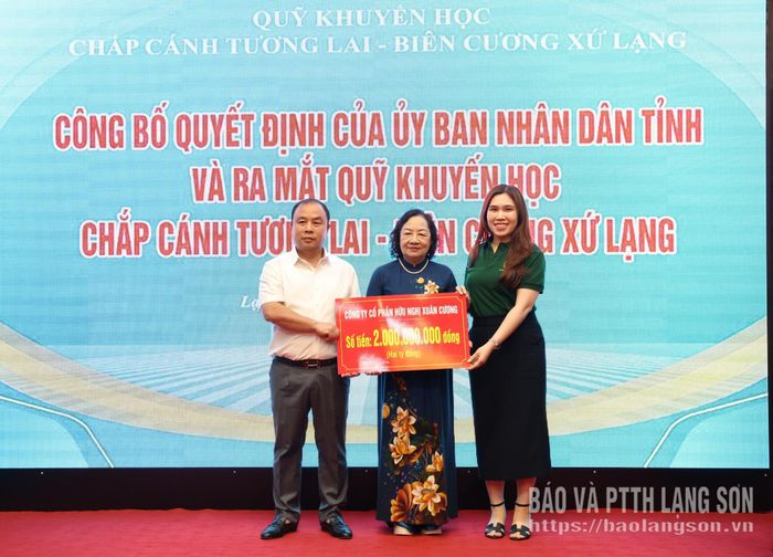 Đại diện Công ty Cổ phần hữu nghị Xuân Cương trao biển tượng trưng kinh phí ủng hộ quỹ