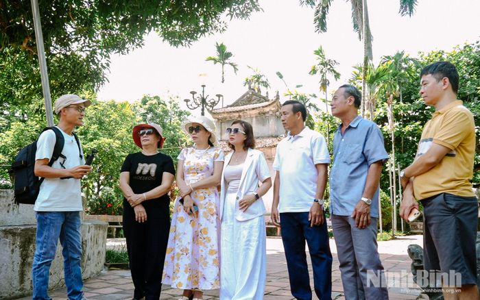 Anh Hùng trao đổi và tìm hiểu về thông tin của điểm du lịch với du khách và người dân địa phương.