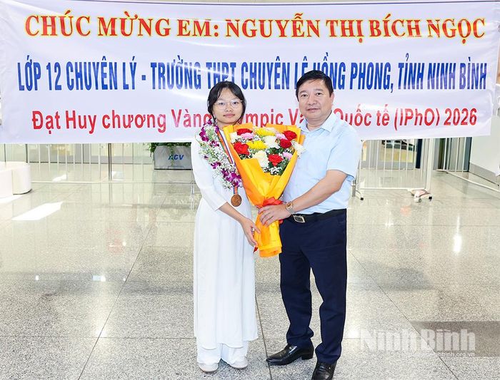 Đồng chí Nguyễn Tiến Dũng, Tỉnh ủy viên, Giám đốc Sở Giáo dục và Đào tạo tặng hoa chúc mừng em Nguyễn Thị Bích Ngọc.