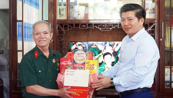 Đồng chí Trần Vũ Khiêm, Phó Bí thư Thường trực Tỉnh ủy, Trưởng đoàn ĐBQH tỉnh thăm, tặng quà thương binh Đinh Gia Bình - Ảnh: N.M