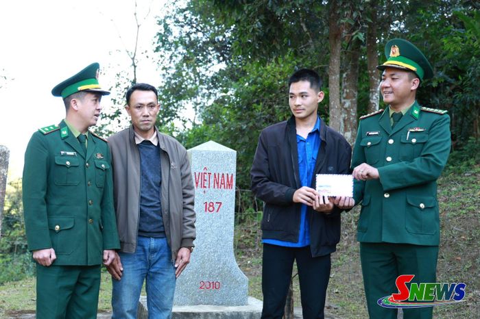 Cán bộ Đồn Biên phòng Mường Lạn trao kinh phí hỗ trợ theo chương trình “Nâng bước em tới trường” cho em Lường Văn Sặn. Ảnh PV
